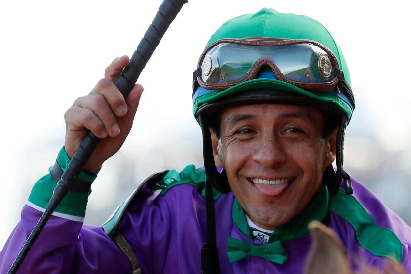 Jockey Victor Espinoza smiles while sitting on top of California Chrome following his victory at the Kentucky Derby on May 3.