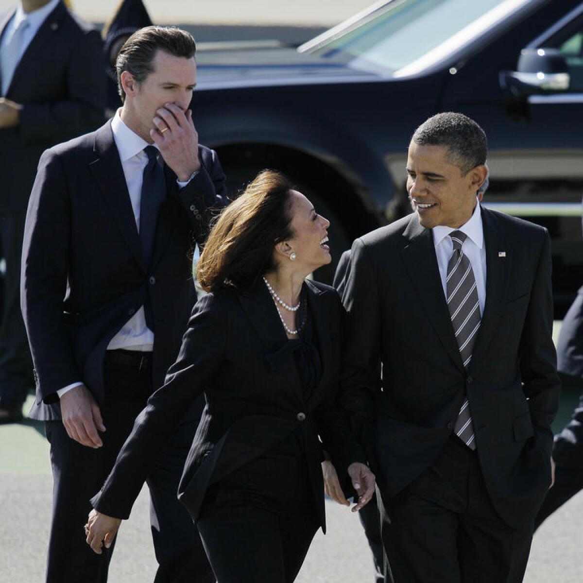 President Barack Obama walks with California Attorney General Kamala Harris, center, and California Lt. Gov. Gavin Newsom, after arriving at San Francisco International Airport in San Francisco in 2012.
