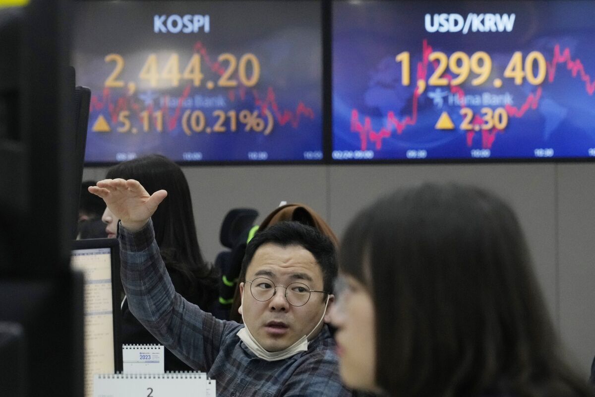 A currency trader gestures at the foreign exchange dealing room of the KEB Hana Bank headquarters in Seoul, South Korea, Friday, Feb. 24, 2023. Shares in Asia were mixed Friday after Wall Street broke its longest losing streak since December with a modest rally led by tech stocks. (AP Photo/Ahn Young-joon)