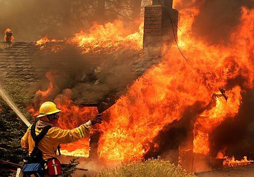 Without aerial support, firefighters are overwhelmed by flames racing through homes in Green Valley Lake on Monday in the San Bernardino Mountains.