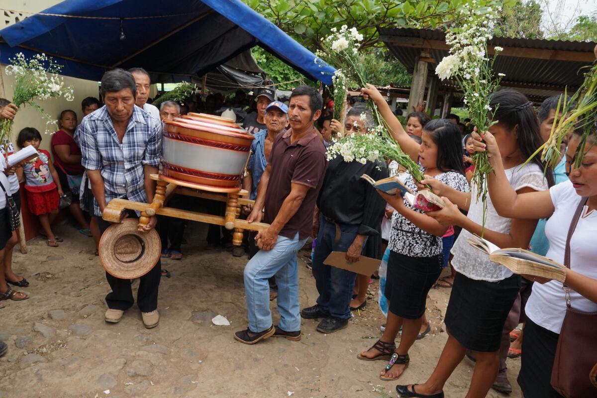 Family members, high school students, parishioners and neighbors bid farewell to cousins Delfino Cash Lopez, 19, and Felix Cash Lopez, 17, as their caskets leave home.
