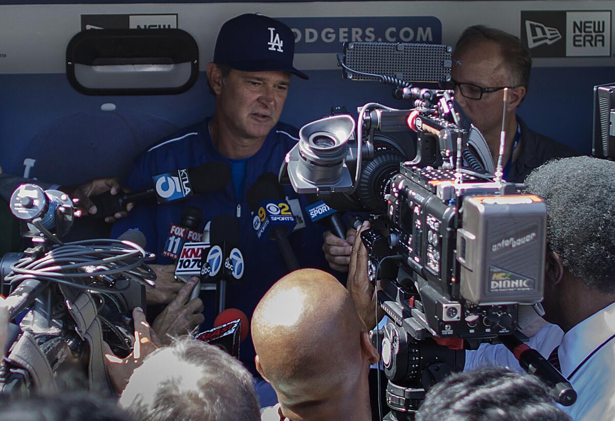 Dodgers Manager Don Mattingly talks to the media in the dugout at Dodger Stadium during a Tuesday workout before the NLDS against the Mets.