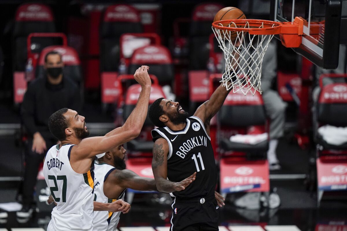 Brooklyn Nets' Kyrie Irving (11) drives past Utah Jazz's Rudy Gobert (27) during the first half of an NBA basketball game Tuesday, Jan. 5, 2021, in New York. (AP Photo/Frank Franklin II)