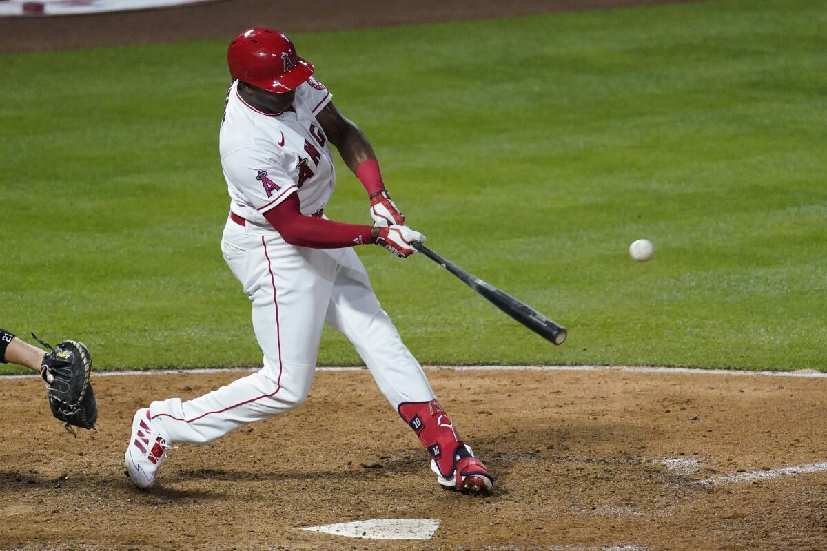 Los Angeles Angels left fielder Justin Upton (10) hits a home run during the eighth inning of a baseball game against the Chicago White Sox Saturday, April 3, 2021, in Anaheim, Calif. Jared Walsh also scored. (AP Photo/Ashley Landis)