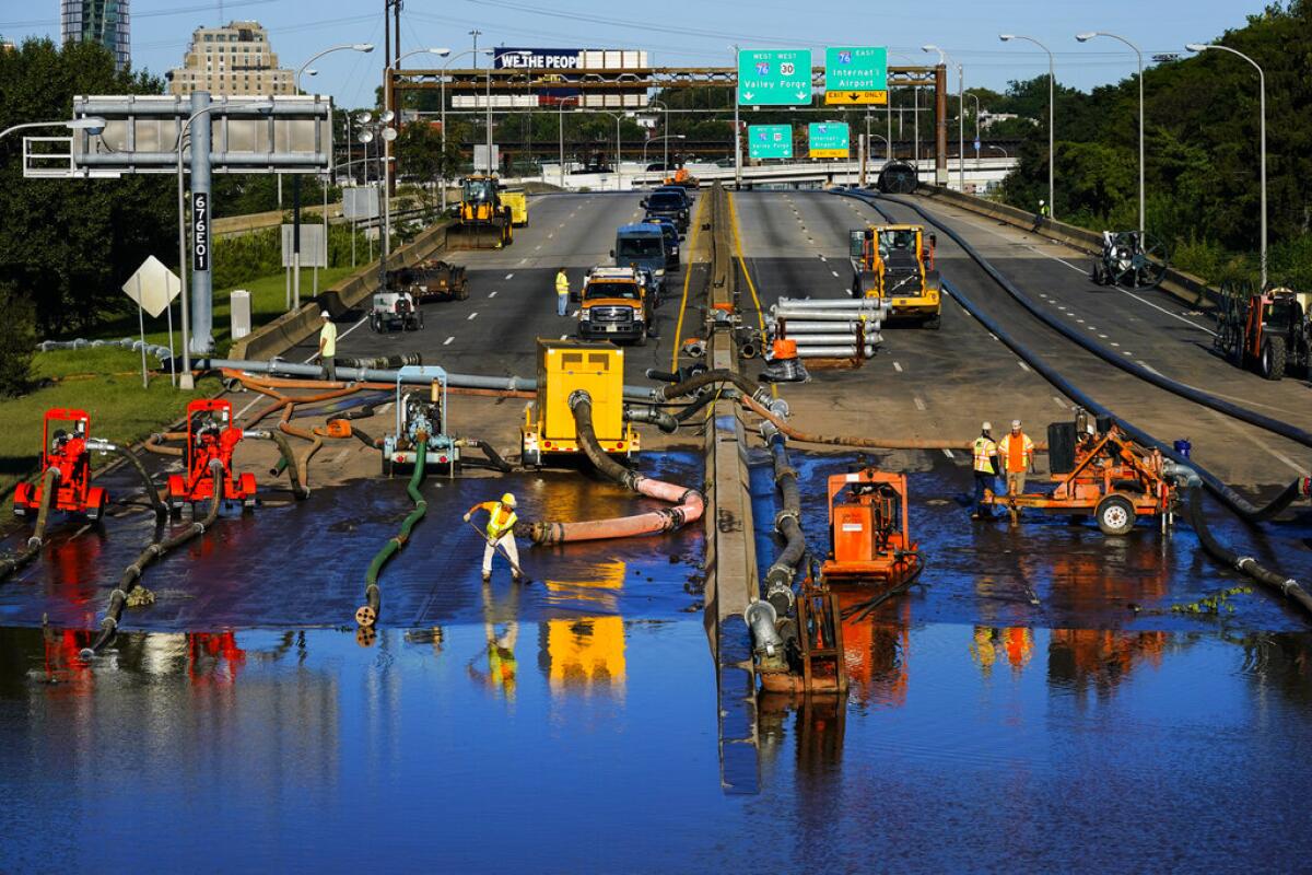 Trabajadores extraen agua de un tramo inundado de a autopista interestatal 676 en Filadelfia