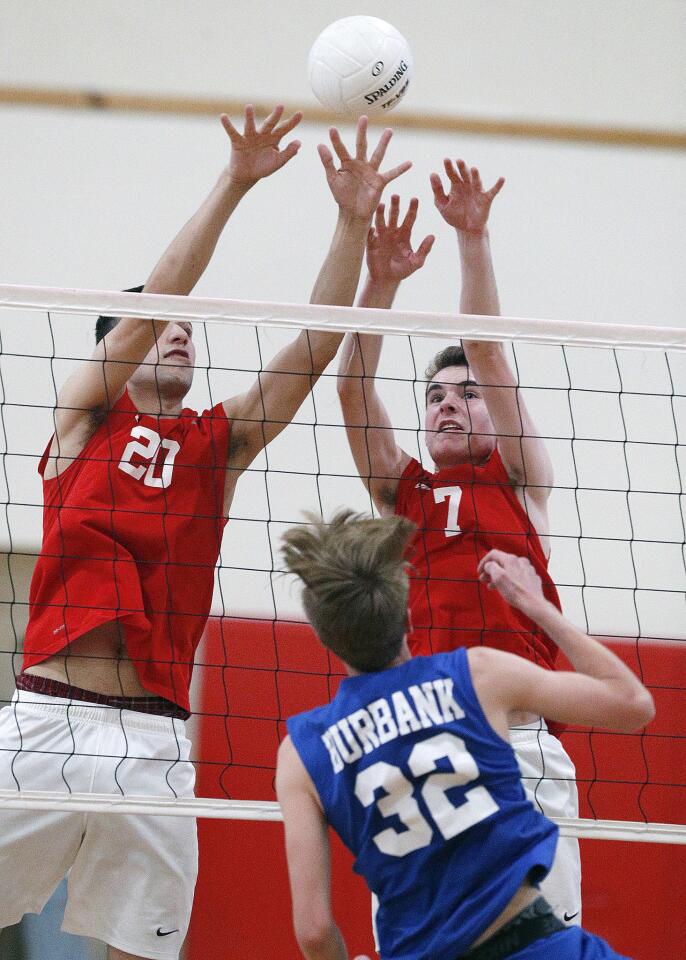 Burroughs' Jagger Green and Luke Kvarda reach for the block against Burbank's Luca Bily in a Pacific League boys' volleyball match at Burroughs High School on Tuesday, April 23, 2019. Burroughs won the match 3-0.