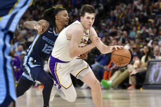 Los Angeles Lakers guard Austin Reaves handles the ball against Memphis Grizzlies guard Ja Morant (12) during Game 1 of a first-round NBA basketball playoff series, Sunday, April 16, 2023, in Memphis, Tenn. (AP Photo/Brandon Dill)