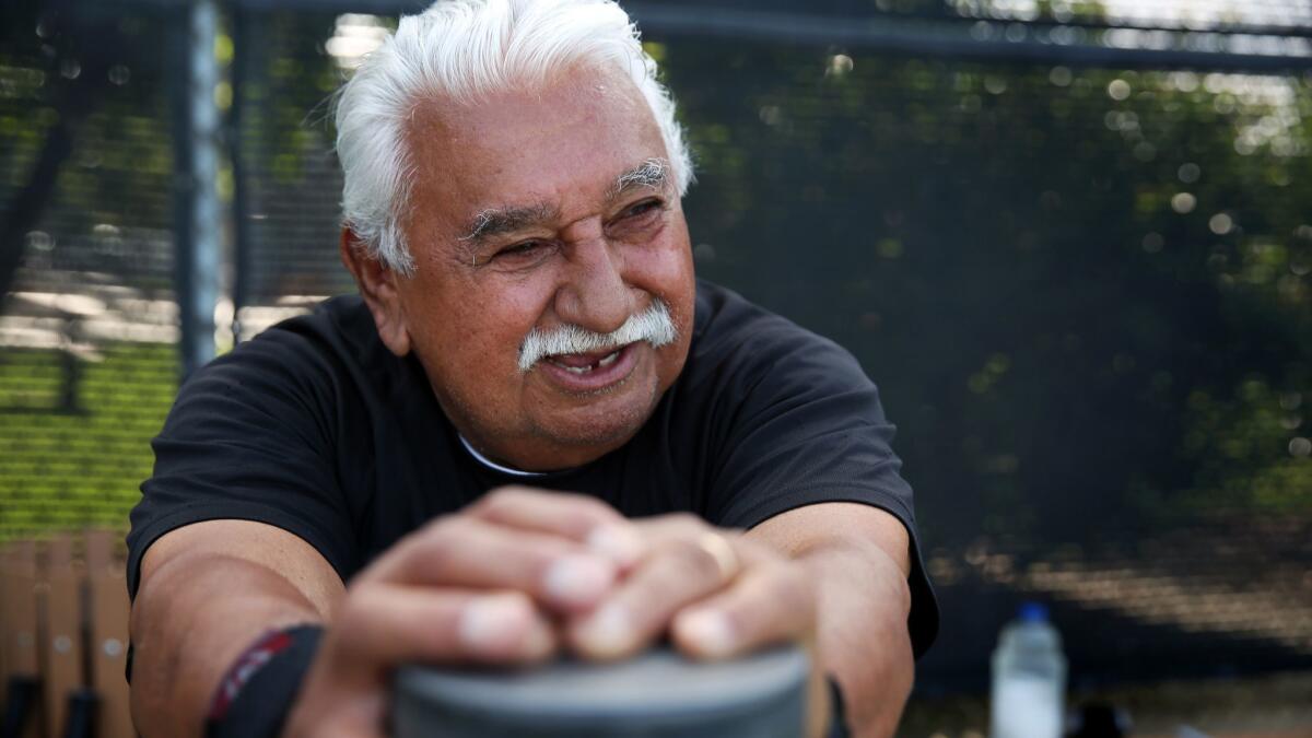 Rocky Garcia, a retired union representative, stretches after playing a tennis match in Downey last month. He meets several other mostly retired people here to play tennis about twice a week.