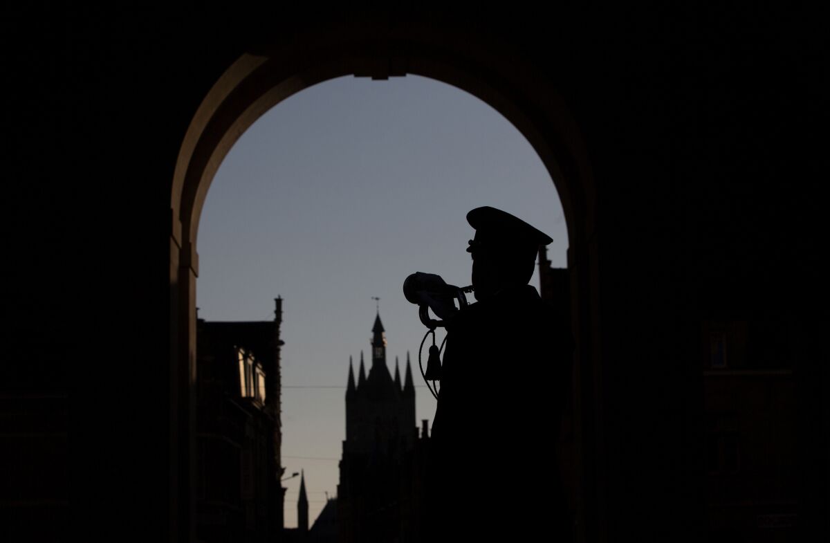 FILE - A lone bugler plays the nightly Last Post under the World War I monument, Menin Gate, in Ypres, Belgium, Saturday, April 25, 2020. Even the Last Post ceremony in Ypres, playing daily since 1928 and only briefly stopped during World War II, was under threat of seeing its string snapped due to COVID-19 regulations. During the pandemic there has been only one bugler, instead of six, playing in the Menin Gate in front of the names of 55,000 soldiers. (AP Photo/Virginia Mayo, File)