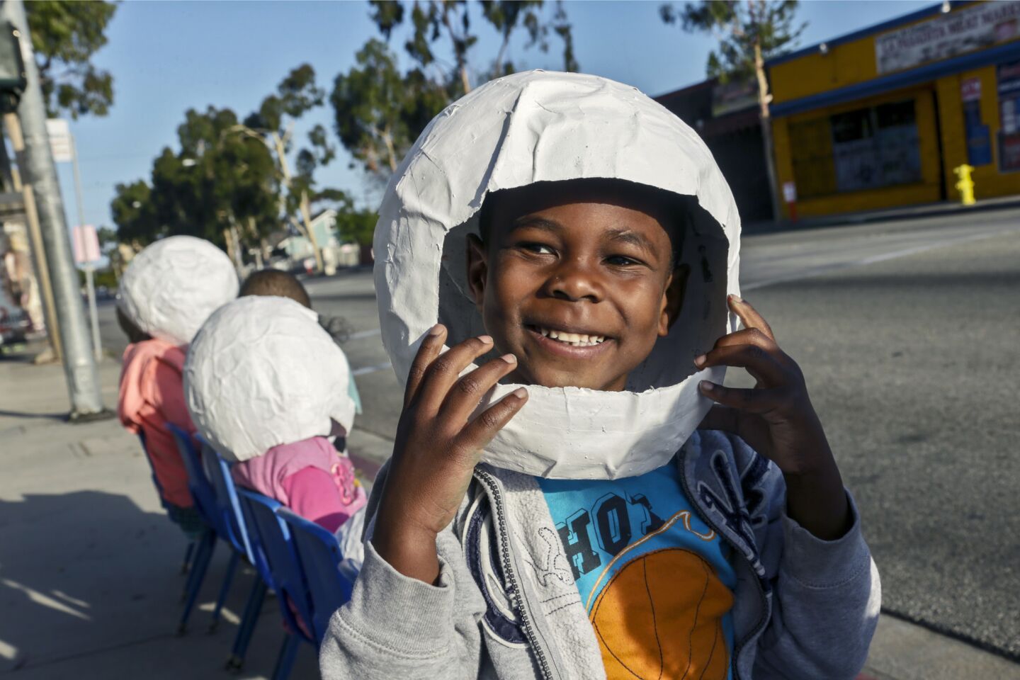 Adren Turner dons an astronaut helmet made from paper as he waits to see ET-94, NASA's last remaining space shuttle external tank, along Arbor Vitae Street in Inglewood.