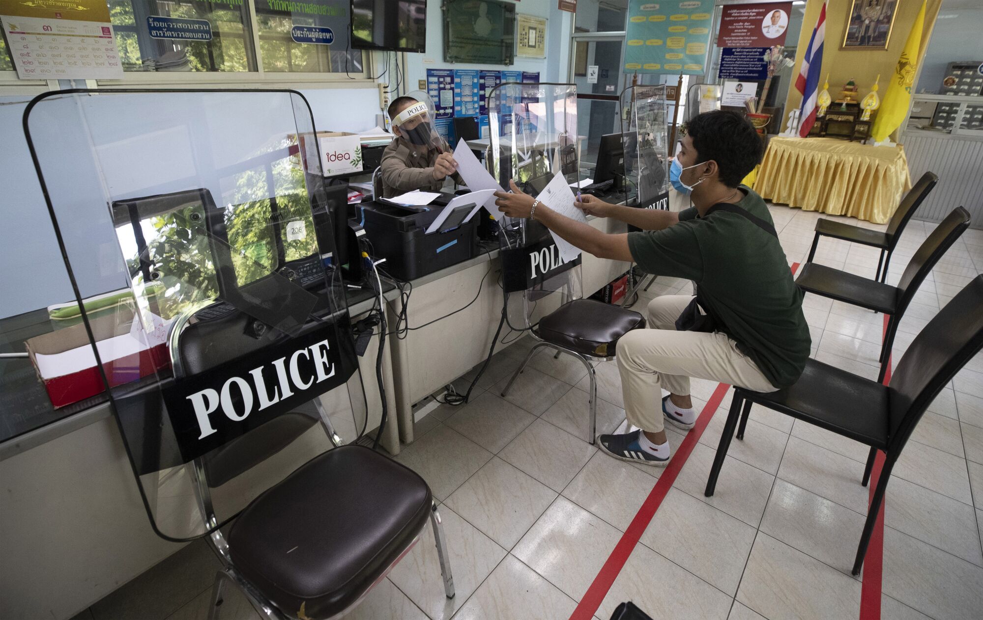 THAILAND: Police use riot shields to practice social distancing to help curb the spread of the coronavirus at the Tha Phra police station.