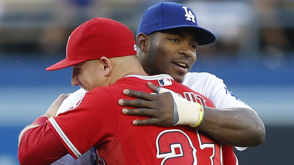 Angels center fielder Mike Trout, front, and Dodgers center fielder Yasiel Puig embrace before a game at Dodger Stadium in August. The Angels and Dodgers represent two of the four California teams competing in the postseason.