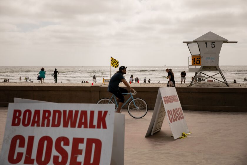 Beachgoers skateboard along the boardwalk in Mission Beach ahead of Memorial Day Weekend on May 22, 2020 in San Diego, California. The boardwalk is currently supposed to be closed to pedestrians except to cross to and from the sand.