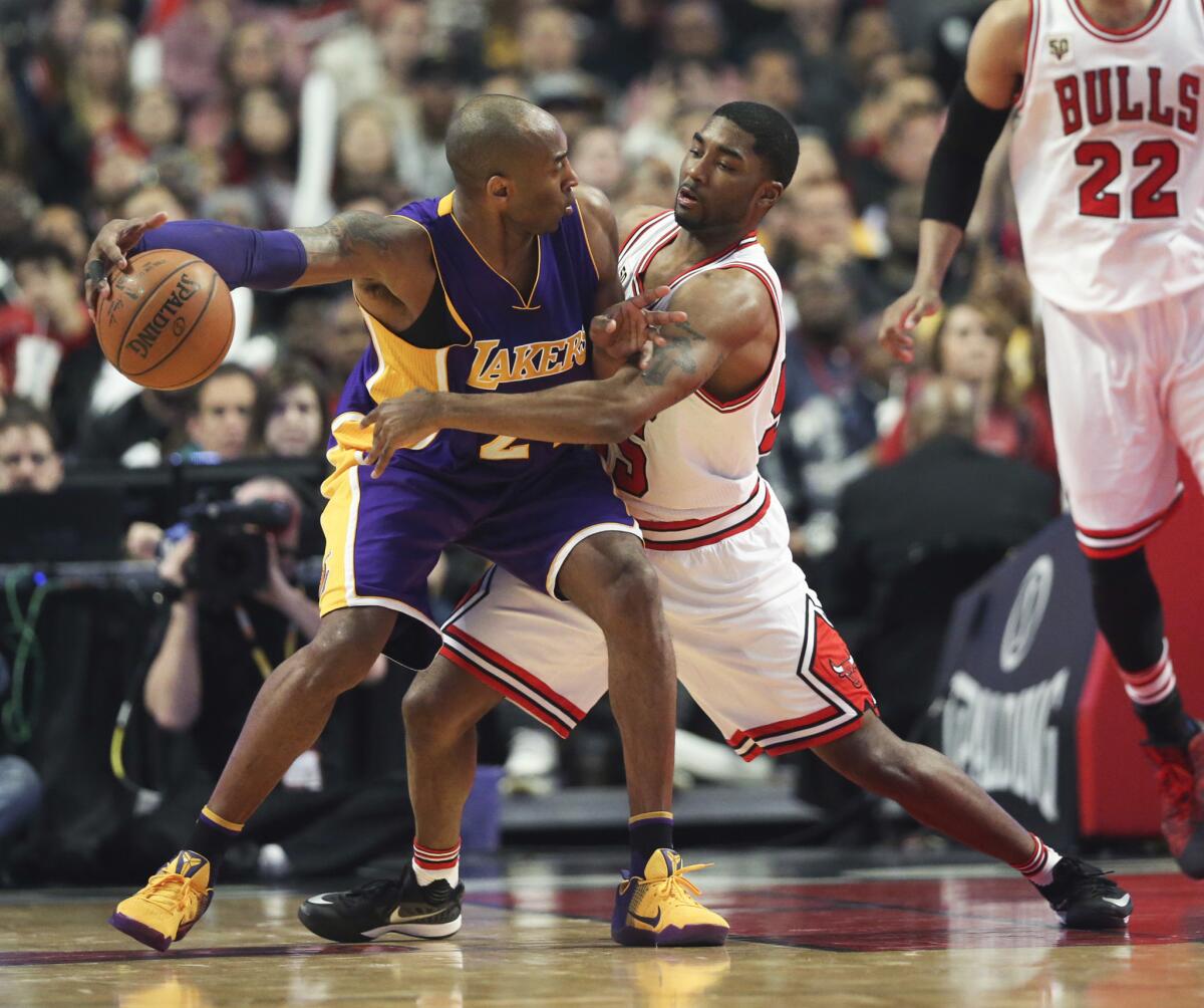 Lakers forward Kobe Bryant (24) keeps the ball away from Bulls guard E'Twaun Moore (55) during the first half.