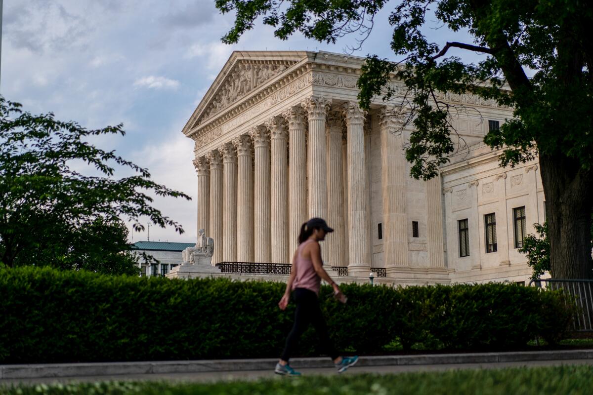 A woman walks past the Supreme Court building