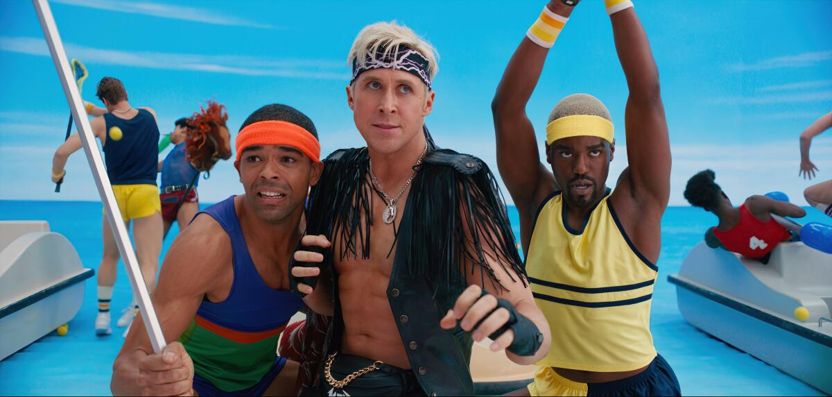 Three men in exercise costumes, one in a fringed black leather vest and sweatband.