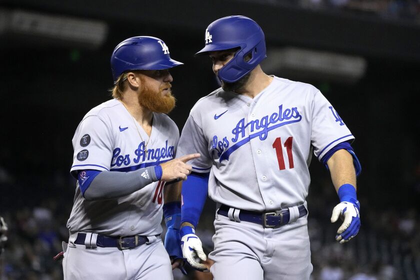 Los Angeles Dodgers' AJ Pollock celebrates with Justin Turner (10) after hitting a two-run home run.