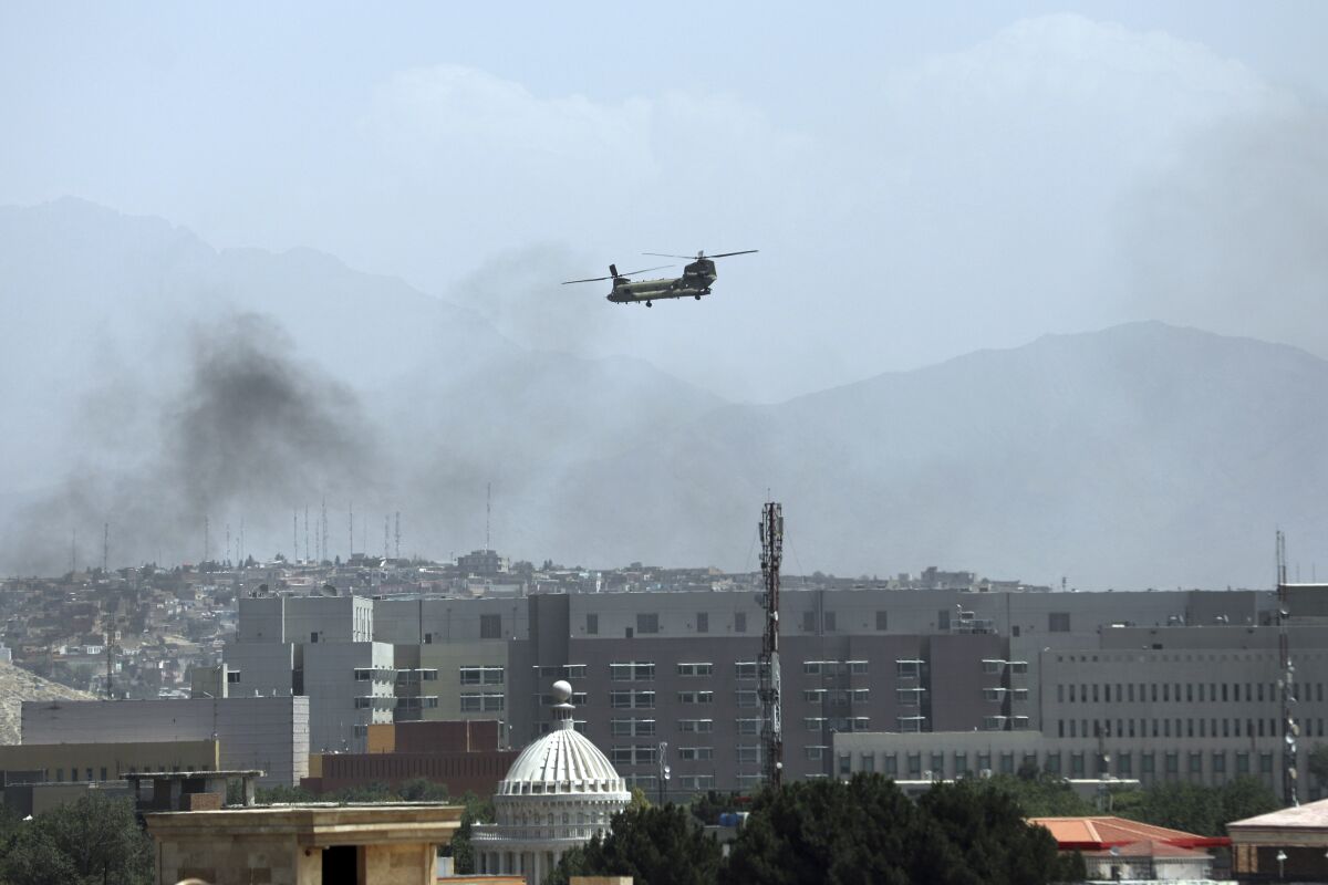 A U.S. Chinook helicopter flies over the city of Kabul, Afghanistan, Sunday, Aug. 15, 2021. Taliban fighters entered the outskirts of the Afghan capital on Sunday, further tightening their grip on the country as panicked workers fled government offices and helicopters landed at the U.S. Embassy. (AP Photo/Rahmat Gul)
