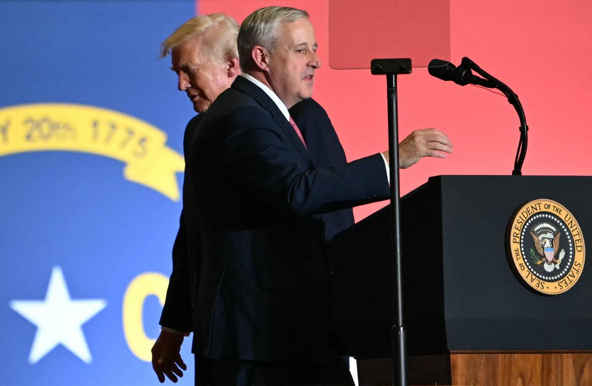 President Trump walks behind former chairperson of the Republican National Committee Michael Whatley.