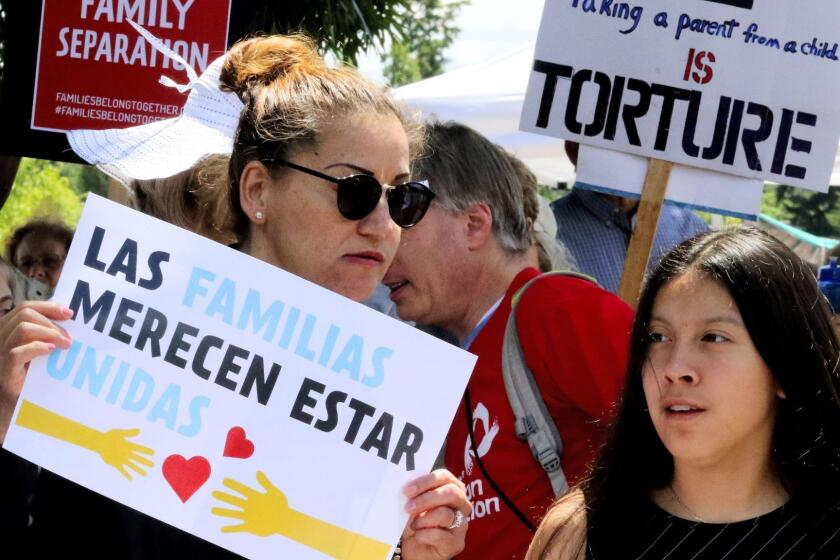 Protesters hold signs against the government separating asylum-seeking parents from their children outside the Federal Detention Center in SeaTac, Wash., on Saturday, June 9, 2018. (Alan Berner/The Seattle Times via AP)