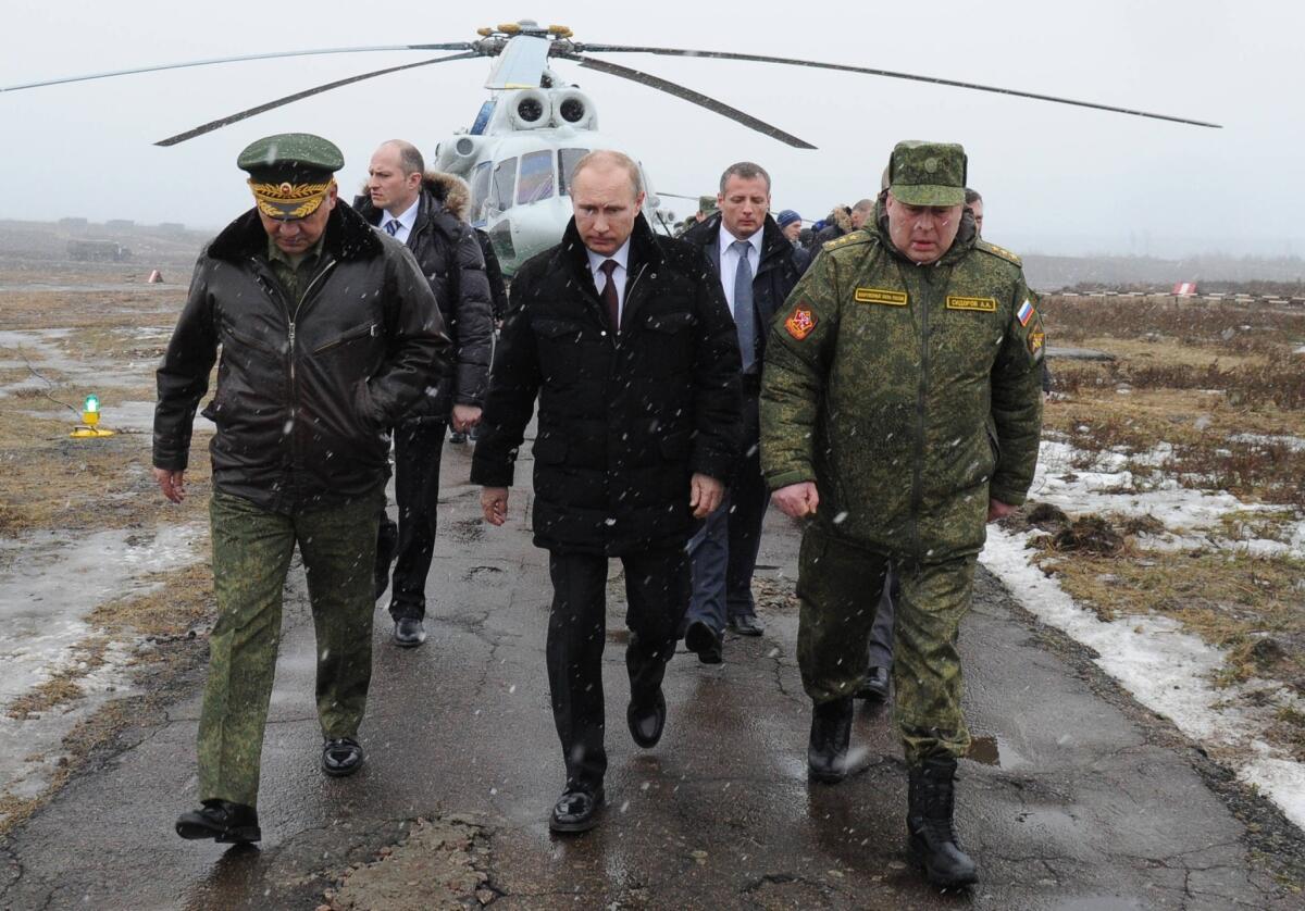 Russian President Vladimir Putin and defense officials walk to watch military exercises upon his arrival at the Kirillovsky firing ground in the Leningrad region on Sunday.