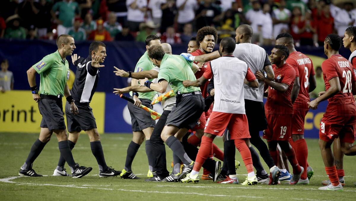 Referee Mark Geiger, left, is charged by some Panama players at the conclusion of a CONCACAF Gold Cup semifinal game won by Mexico on Wednesday.