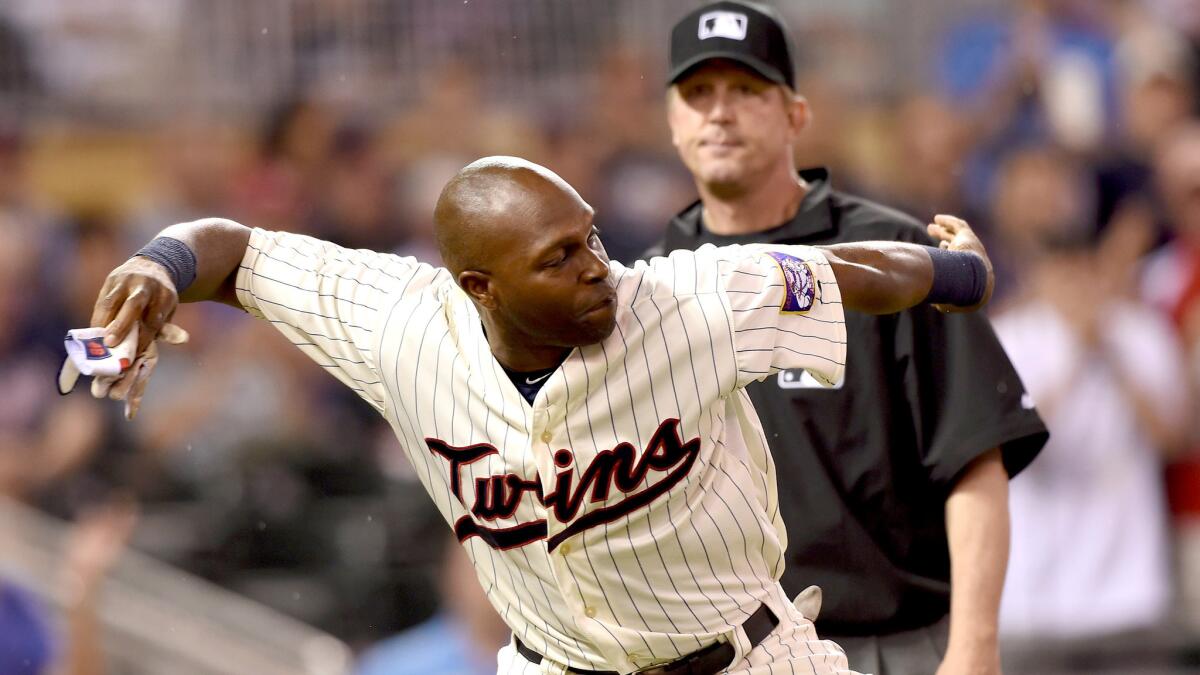 Umpire Jeff Kellogg watches as Twin outfielder Torii Hunter throws his batting glove onto the field after getting ejected from a game against the Kansas City Royals on June 10.
