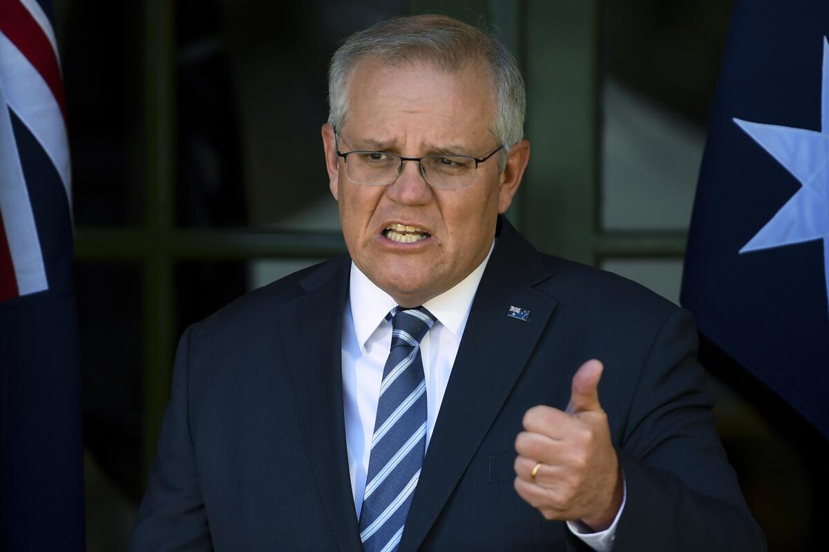 Australia's Prime Minister Scott Morrison speaks during a press conference in Canberra, Thursday, Oct. 7, 2021. Morrison has described social media as a "coward's palace" and warned digital platforms such as Facebook could be held liable for defamatory comments posted anonymously. (Lukas Coch/AAP Image via AP)