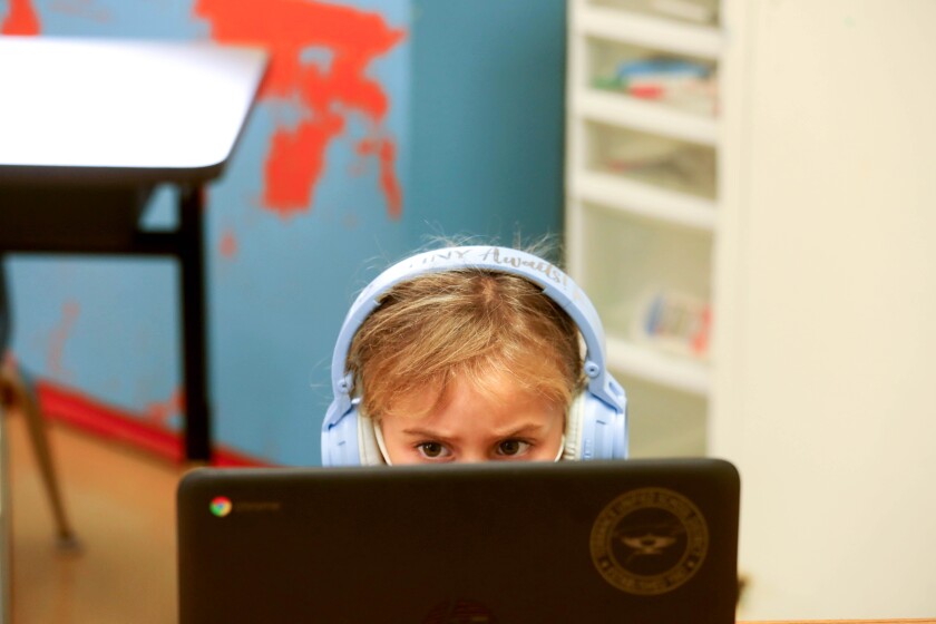 A student seated in front of a computer participates in remote learning in September 2020. 