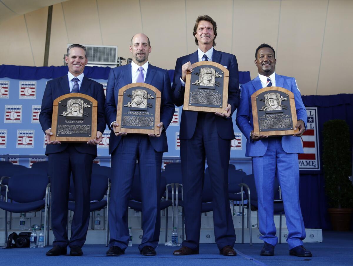 Newly-inducted National Baseball Hall of Famers from left to right, Craig Biggio, John Smoltz, Randy Johnson and Pedro Martinez hold their plaques in Cooperstown, N.Y.
