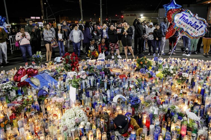 LOS ANGELES, CALIF. -- TUESDAY, APRIL 2, 2019: Community members pay their respects to the slain Nipsey Hussle at a makeshift memorial outside his Marathon Clothing store in Los Angeles, Calif., on April 2, 2019. (Marcus Yam / Los Angeles Times)
