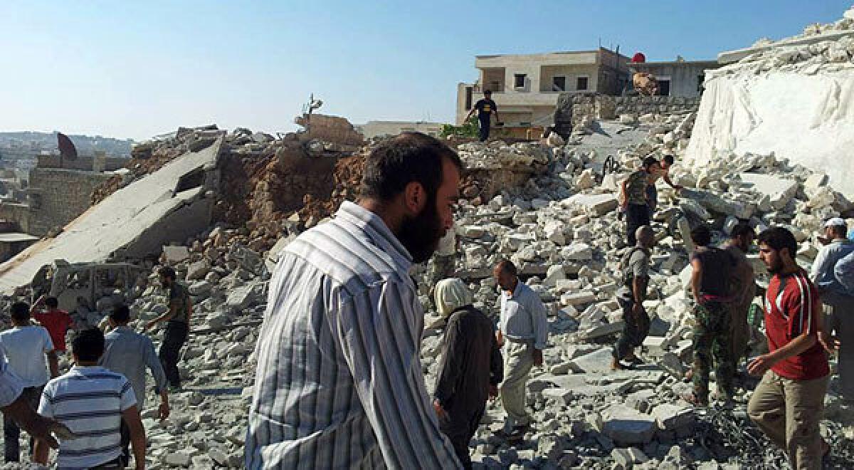 This image provided by The Syrian Revolution Against Bashar Assad shows Syrian citizens in the rubble of destroyed houses in Aleppo, Syria.