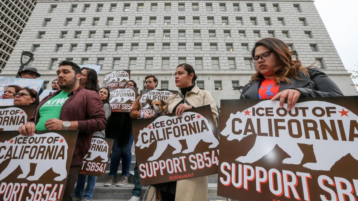 Supporters of state sanctuary bill SB 54 rally outside the Hall of Justice.