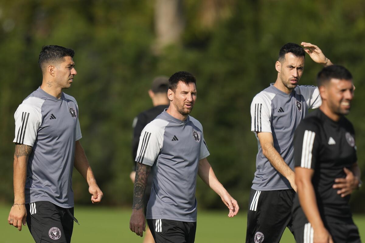 Inter Miami forward Luis Suarez, left, walks with forward Lionel Messi, center, and defender Sergio Busquets, second right, during an MLS soccer training session, Saturday, Jan. 13, 2024, in Fort Lauderdale, Fla. (AP Photo/Rebecca Blackwell)