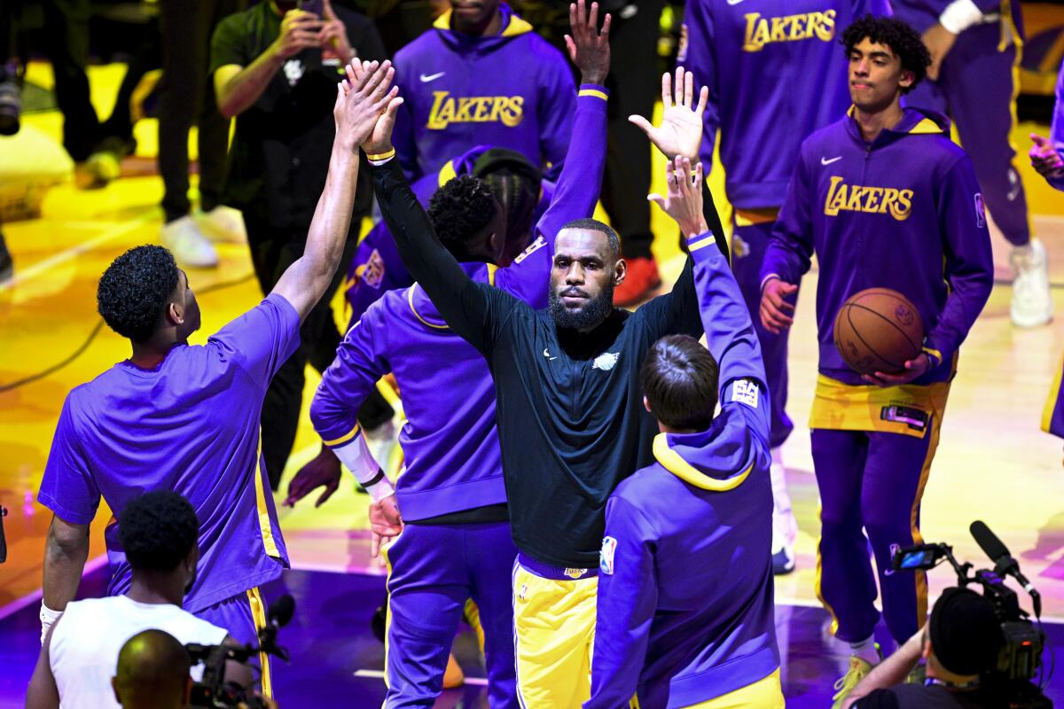 Lakers forward LeBron James, center, receives high-fives from teammates as he's introduced before a playoff game.