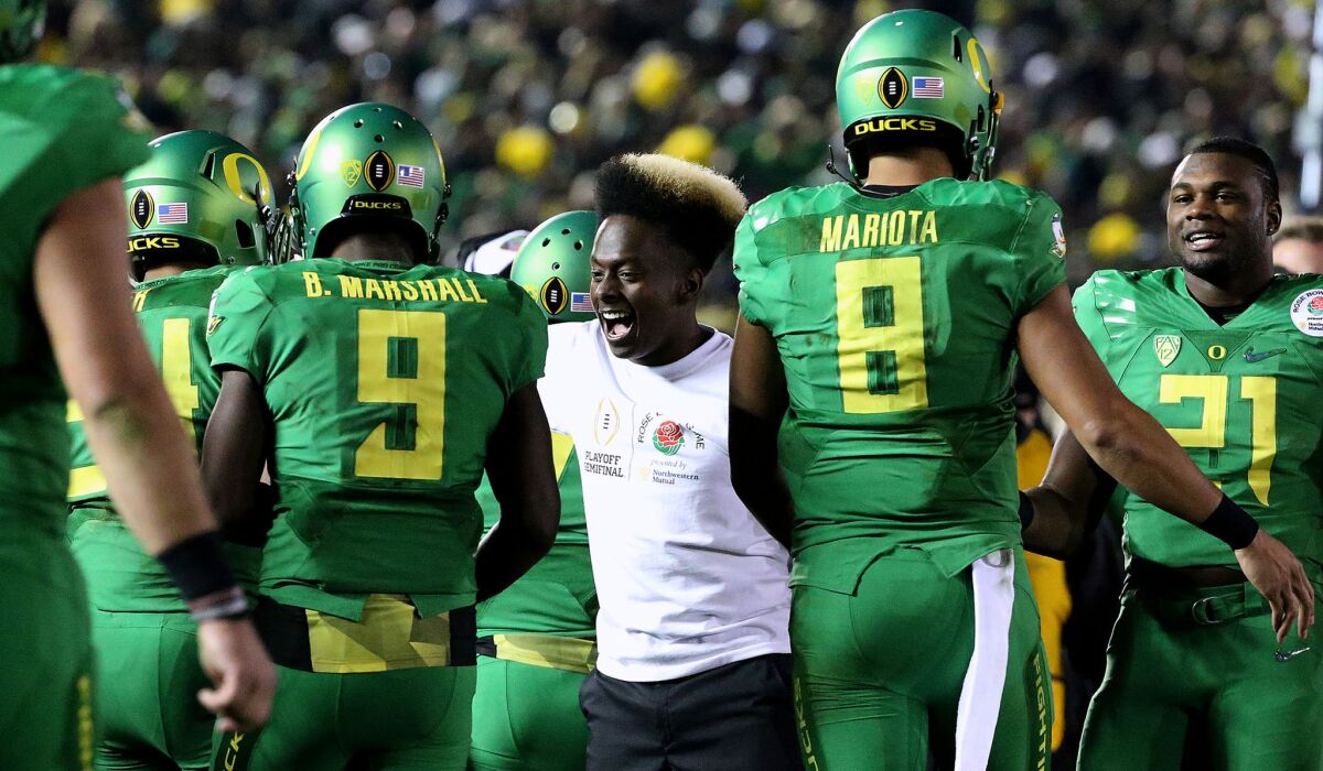 Ball boy Kwame Mitchell joins in the celebration after the Ducks scored another touchdown against Florida State in a 59-20 victory in a College Football Playoff semifinal at the Rose Bowl.