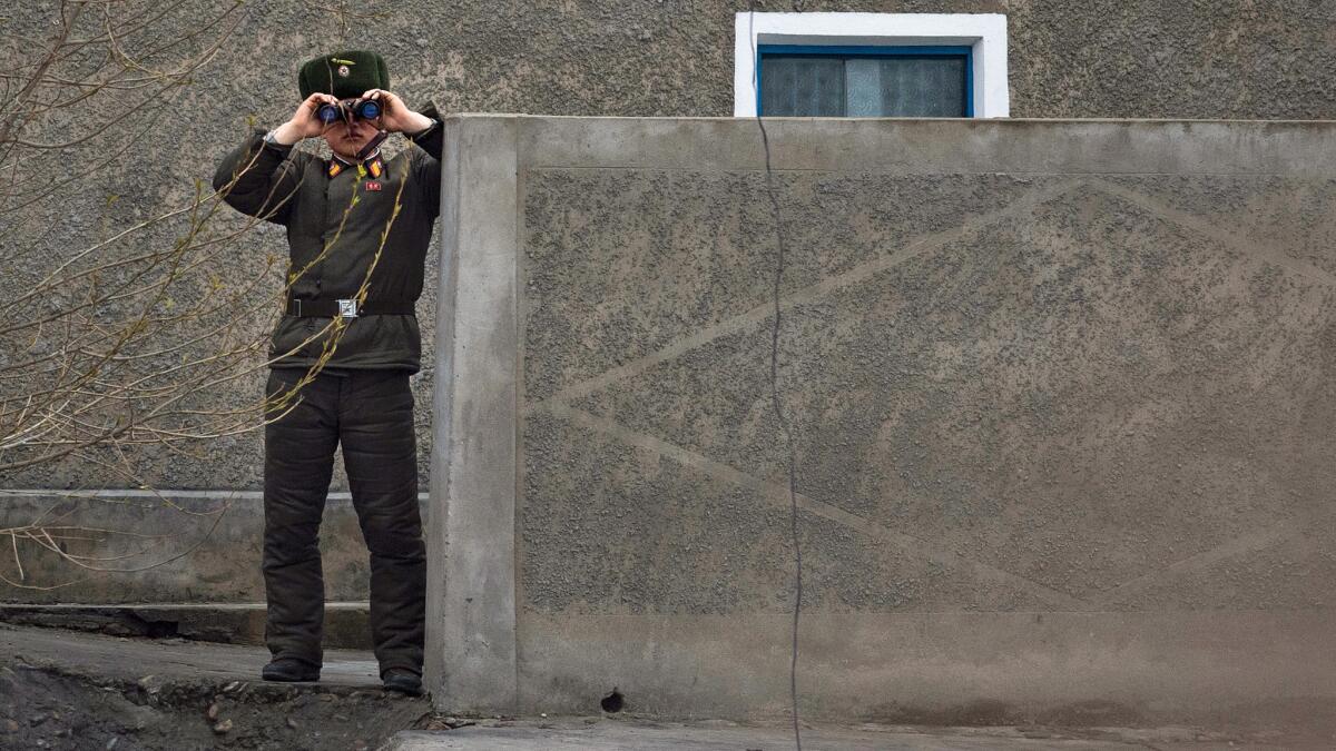 A North Korean soldier looks across the banks of the Yalu river into China. (Johannes Eisele / AFP/Getty Images)