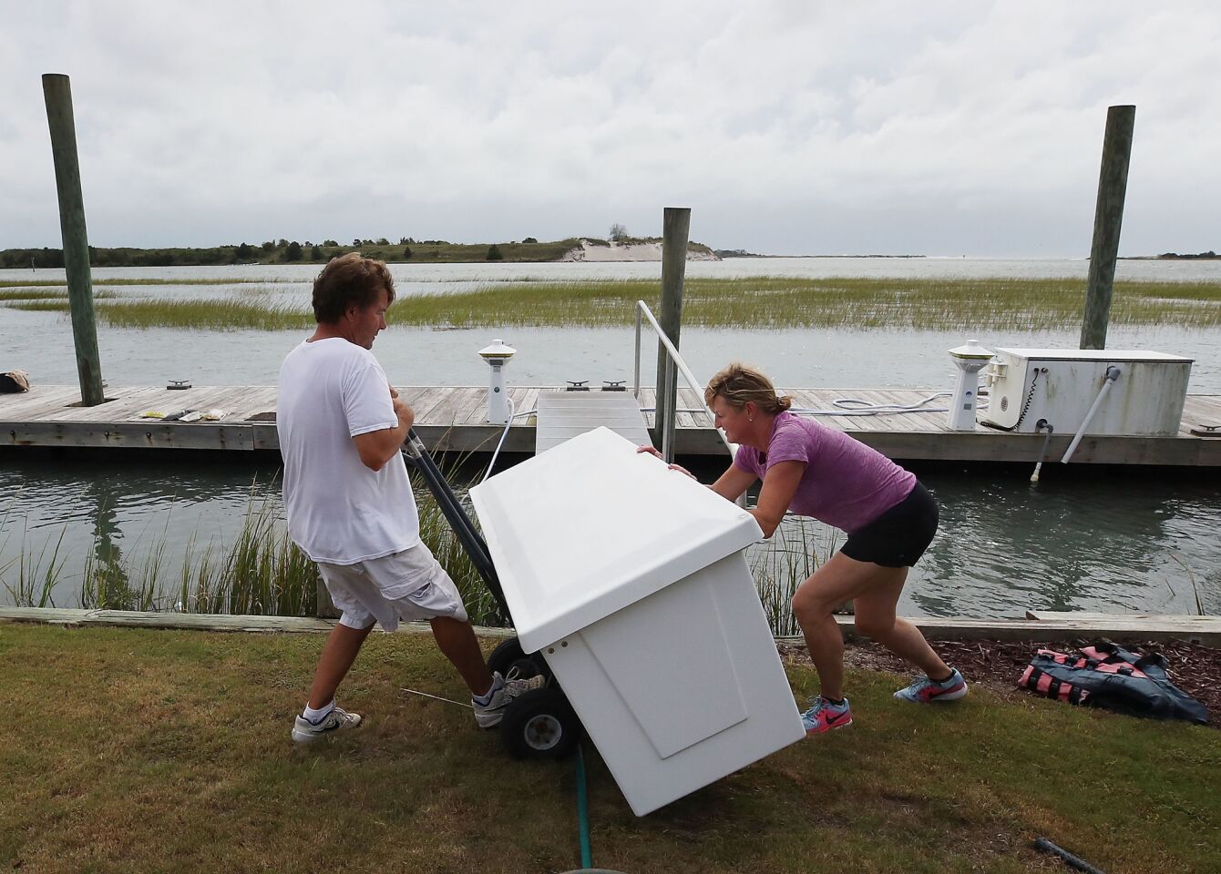 WILMINGTON, NC - SEPTEMBER 13: Mike Pollack and his wife Meredith Pollack move a dock box from their dock as Hurricane Florence approaches the area, on September 13, 2018 in Wilmington, North Carolina. Hurricane Florence is expected on early Friday possibly as a category 2 or 3 storm along the North Carolina and South Carolina coastline.