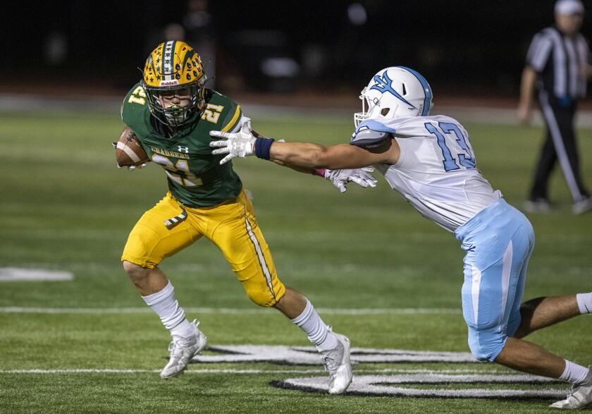 Edison's Troy Fletcher runs upfield under pressure from Corona del Mar's Christian Brooks.