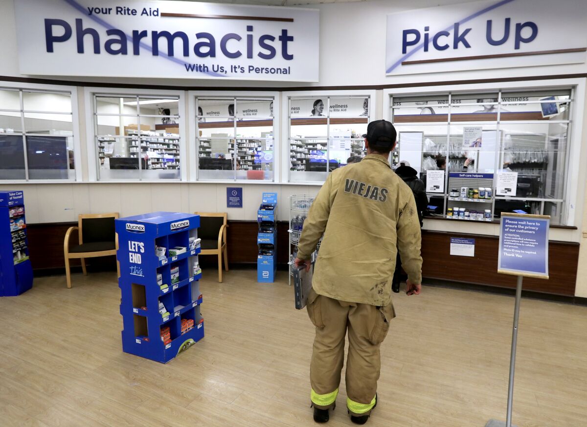 Fire line doctor Aaron Thomas waits to pick up prescription drugs from a pharmacy 