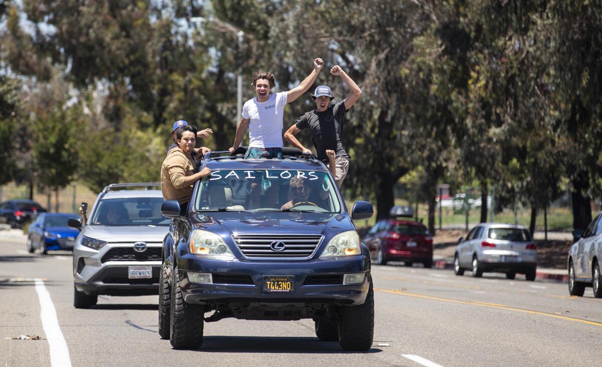 Students from Newport Harbor High School drive by Estancia High School.