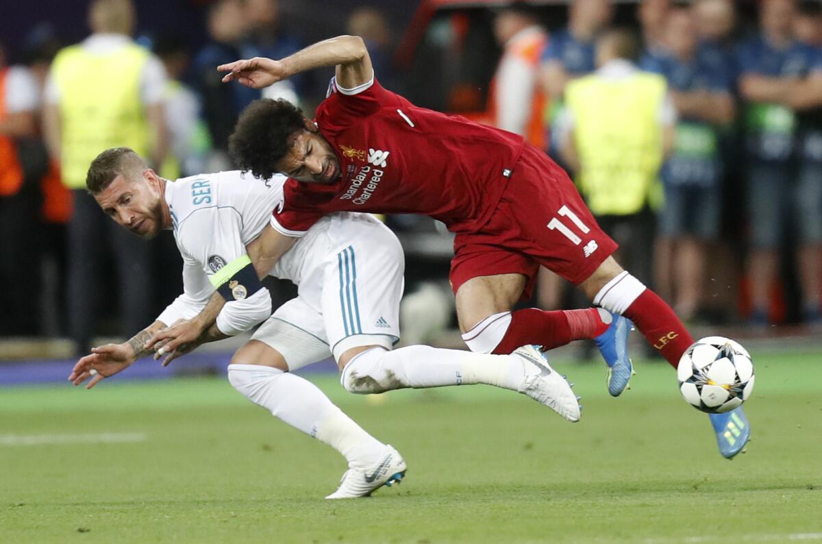 Sergio Ramos (izquierda) del Real Madrid comete una falta a Mohamed Salah del Liverpool en la final de la Liga de Campeones, en Kiev, Ucrania, el sábado 26 de mayo de 2018.