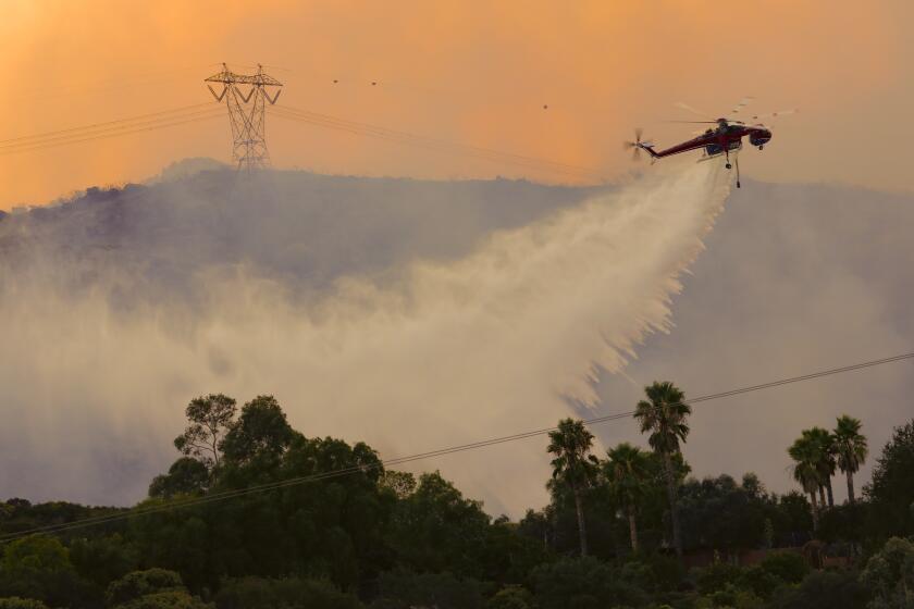 Large crane helicopters drop water on the Valley fire.
