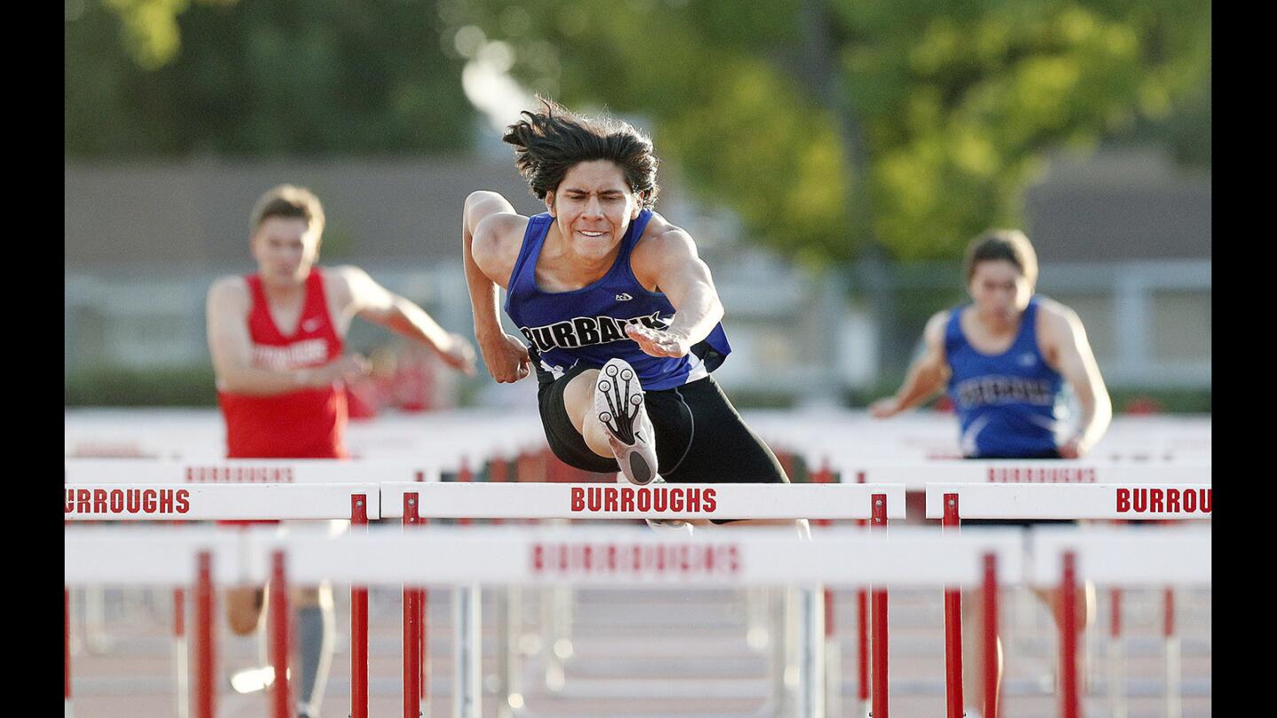 Burbank's Sergia Aguilar clears the high hurdles in first place against Burroughs in a rival Pacific League track meet at Burroughs High School on Thursday, April 19, 2018.