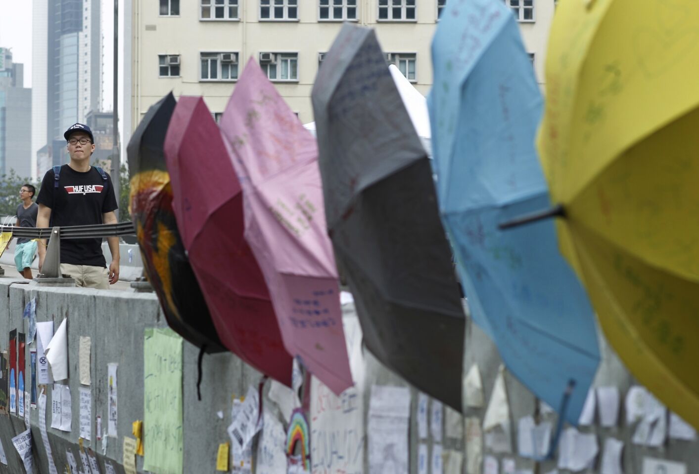 A man passes umbrellas displaying slogans in the protesters' encampment outside the Hong Kong government complex.