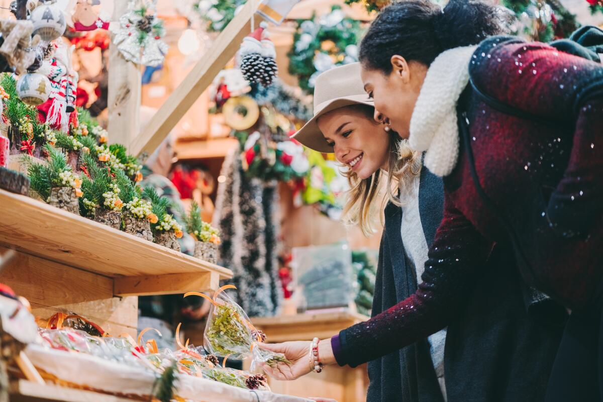 Friends choosing Christmas gifts at the Christmas market