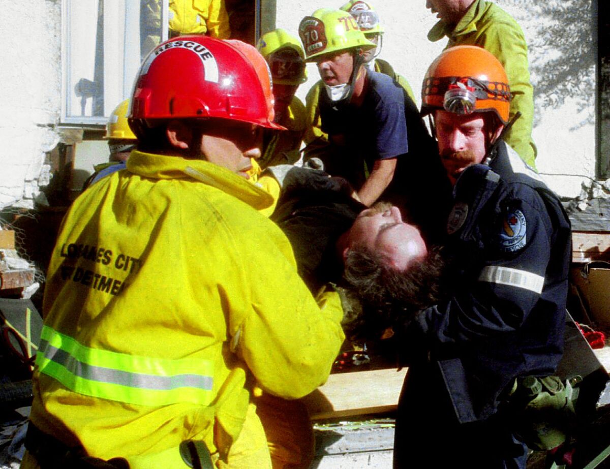 LAPD Reserve Search & Rescue worker Don Stein, right, helps remove Steve Langdon from the collapsed Northridge Meadows apartments.