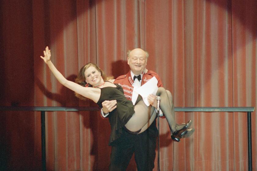 New York Mayor Ed Koch gives a lift to Broadway dancer and actress Ann Reinking during a performance in 1987.