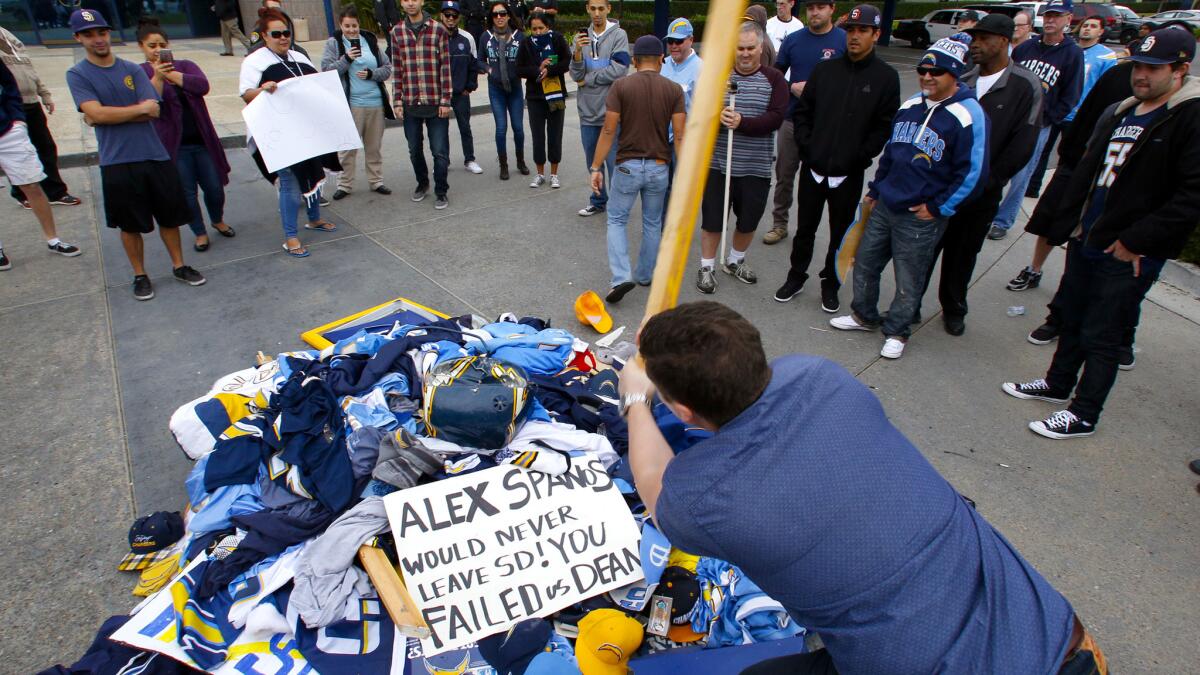 Stephen Black smashes a pile of Chargers memorabilia outside the team's complex in San Diego on Thursday.