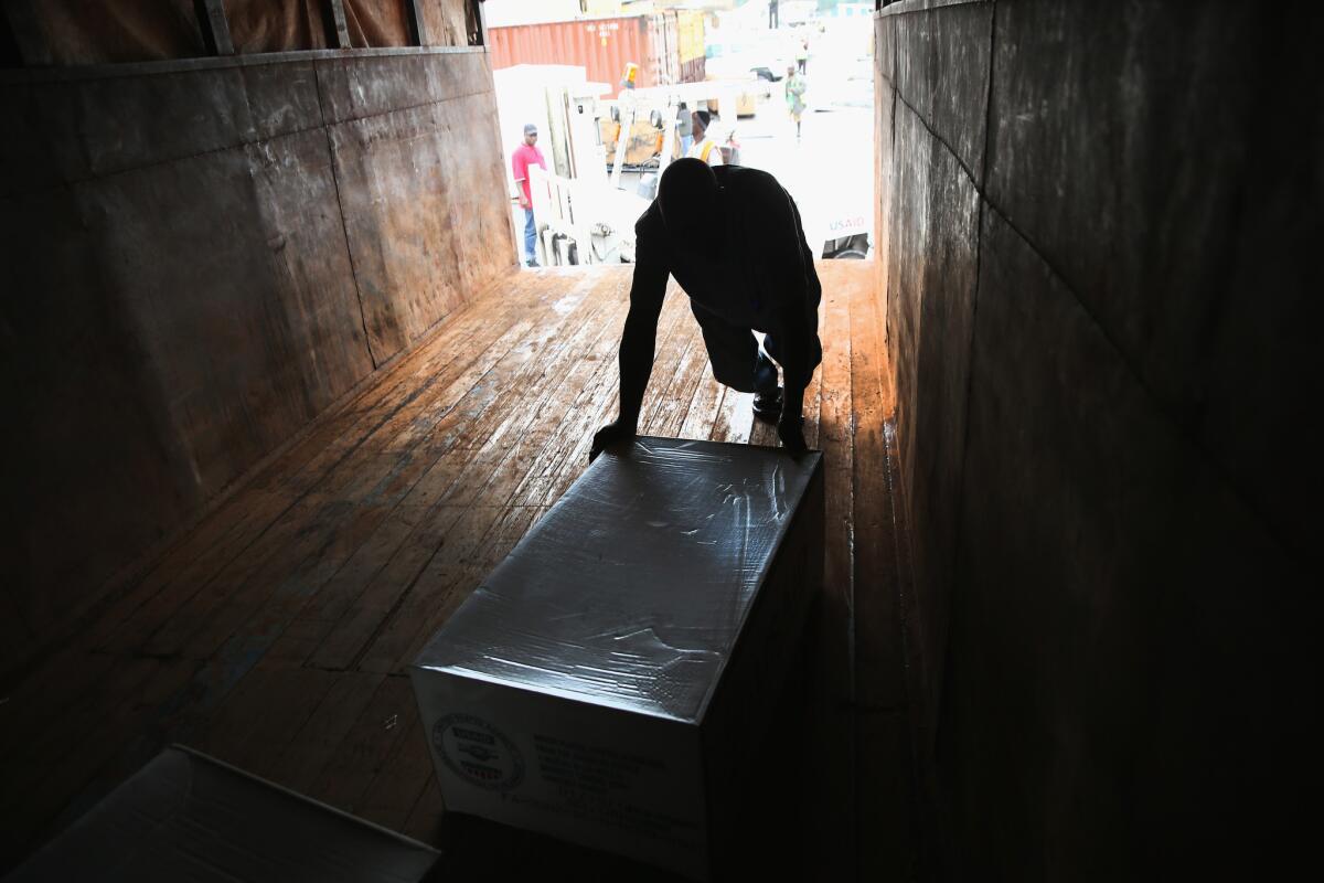 A worker unloads medical supplies for use against Ebola from a U.S. Agency for International Development cargo flight in Harbel, Liberia.